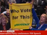 Dos activistas de Greenpeace protestan durante el discurso de Liz Truss al cierre del congreso del partido conservador.