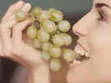 Una mujer comiendo uvas, en una imagen de archivo.