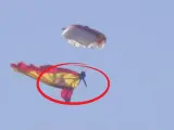 A un paracaidista se le enrolla la bandera en la pierna durante el desfile del 12 de octubre