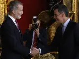 El rey Felipe VI saluda al presidente del Gobierno, Pedro Sánchez (d), a su llegada a la tradicional recepción a las altas autoridades del Estado y a representantes del mundo político, económico, social y cultural, tras el desfile por el Día de la Fiesta Nacional de 2022.