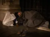 Una persona sin hogar duerme en el Paseo de Gracia de Barcelona, en una imagen de archivo.