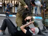 Soldados israelíes detienen a un palestino durante protestas en Hebrón, Cisjordania.