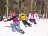 Unos niños abrigados juegan en la nieve.