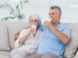 Dos adultos mayores bebiendo leche.