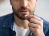 Un hombre tomándose una pastilla