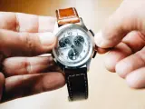 Una persona cambia la hora con las manecillas de reloj