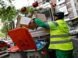 Un operario de recogida de residuos protegidos con mascarilla extrae cajas de cartón de un cubo de basura para triturarlas en un camión de basura durante su trabajo de limpieza en una calle de la capital durante el día 33 del estado de alarma, en Madrid (España), a 16 de abril de 2020. CORONAVIRUS;COVID-19;ESTADO DE ALARMA;LIMPIEZA;PANDEMIA;MASCARILLA;CAMIÓN DE LIMPIEZA; Jesús Hellín / Europa Press (Foto de ARCHIVO) 16/4/2020