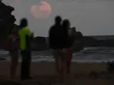 Un grupo de personas observa el eclipse de 'luna de sangre', en una playa de Stanwell Park (Australia).