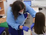 Una sanitaria vacuna a una niña frente a la gripe en Andalucía.