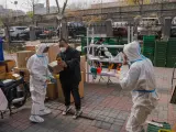 Trabajadores sanitarios voluntarios preparan bolsas con verduras para residentes confinados en Beijing, China, el 28 de noviembre de 2022.