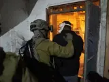 Un soldado israelí escolta a un hombre durante una redada en Cisjordania.