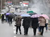 Varias mujeres de etnia serbia caminan bajo sus paraguas junto a un corte de carretera en el pueblo de Rudare, Kosovo, este domingo.