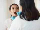 Una profesional examina la cavidad oral de una paciente.