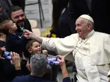 El Papa Francisco agarra el chupete de un bebé durante la audiencia general semanal en el Aula Pablo VI, Ciudad del Vaticano.