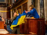 Zelenski entrega a Nancy Pelosi la bandera de guerra de Ucrania.