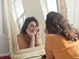 Mujer feliz mirándose al espejo