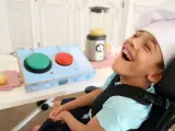 Un niño con discapacidad junto a un juguetes de pulsador