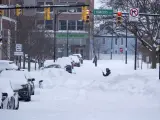 Varias personas se abren paso entre la nieve en una calle de Búfalo, en EE UU.
