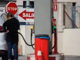 Una mujer reposta en una gasolinera.