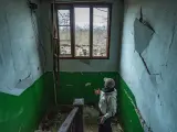 Devastación de paredes y ventanas en un edificio durante un bombardeo sobre un pueblo de Donbass.