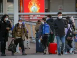 Personas con maletas en el aeropuerto internacional de Pekín, este domingo.