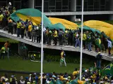 Los manifestantes portan una enorme bandera amarilla y verde.