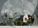 Un manifestante asoma por una ventana destrozada en Brasilia.