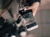Una joven saca una foto con su teléfono móvil.