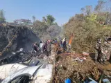 Los equipos de rescate trabajan en los restos de un avión de Yeti Airlines después de que se estrellara en Pokhara, Nepal
