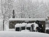 Una persona despeja de nieve el acceso a un restaurante en Roncesvalles, donde la situación meteorológica va mejorando esperando que el temporal se vuelva a recrudecer con la llegada de la borrasca Fien.