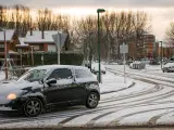 Una mujer conduce un coche cubierto de nieve en Burgos.