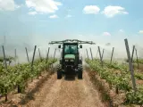 Imagen de archivo de un agricultor trabajando una tierra con un tractor.