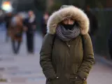 Una mujer paseando por Madrid, que está en aviso amarillo por temperaturas mínimas.