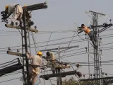 Imagen de archivo de varios técnicos paquistaníes trabajando en torres eléctricas de alto voltaje en Lahore, el 13 de enero de 2011.