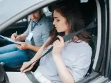 Una chica poniéndose el cinturón durante el examen práctico de conducir.