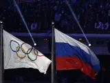 Una bandera de Rusia ondea junto a la bandera olímpica.