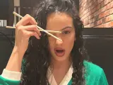 Rosalía con unos palillos chinos.