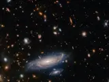 En la parte inferior está LEDA 2046648, una galaxia espiral que se encuentra en la constelación de Hércules.