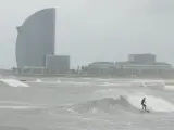 Un surfista en la playa de la Barceloneta este martes, a pesar del temporal marítimo Isaak que ha llegado a la ciudad.