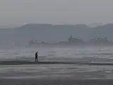 Una persona pasea por la playa de la Malvarrosa