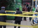 Los transeúntes observan cómo los policías de Nueva York investigan la escena de un tiroteo que dejó a un hombre muerto en Nueva York, el 9 de febrero de 2023.