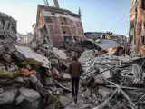 Un hombre camina junto a edificios derrumbados tras un fuerte seísmo