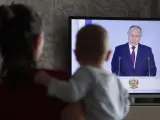 Una familia escuchando el discurso de Putin en Mosc&uacute;