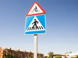 Señal de advertencia bicicleta sobre indicación de cruce de peatones.