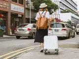 Una turistica arrastrando una maleta en un país asiático.