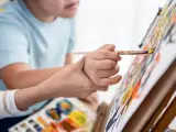 Un niño con discapacidad pintando con ayuda