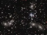 El telescopio espacial James Webb tomó una fotografía de 50.000 astros. Los puntos blancos son galaxias del cúmulo de Pandora que muestran efectos de lente gravitacional, mientras que los rojos aparecen distorsionados con formas irregulares porque están distantes.