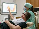 Un paciente muestra al dentista la necesidad de intervención en sus dientes