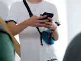 Un joven chatea a través de su teléfono móvil.