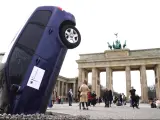 La organización Greenpeace ha organizado este miércoles una performance donde se muestra un coche tipo SUV estrellado contra el pavimento frente a la puerta de Brandenburgo